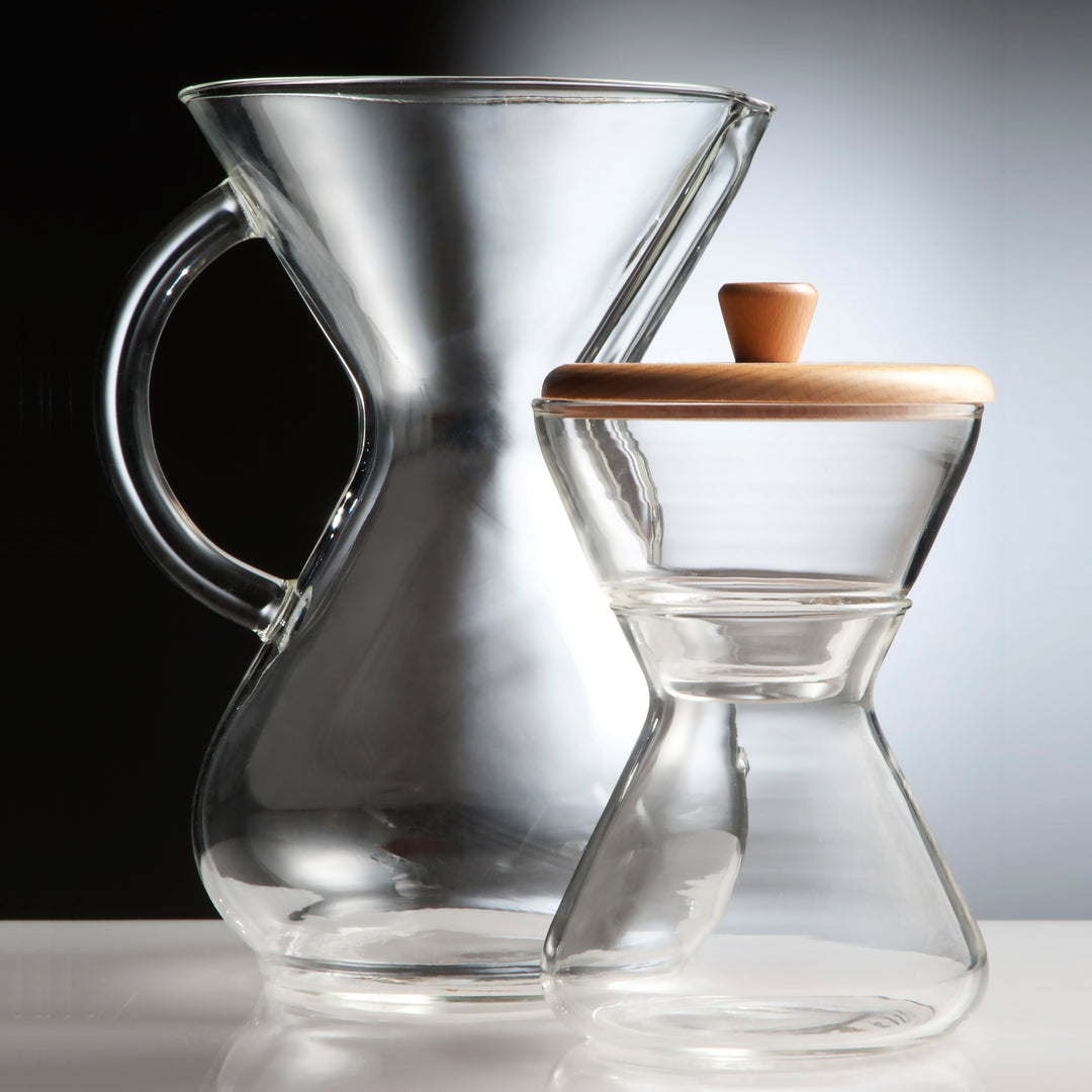 Artsy beauty shot of a chemex glass handle coffeemaker and the cream and sugar set