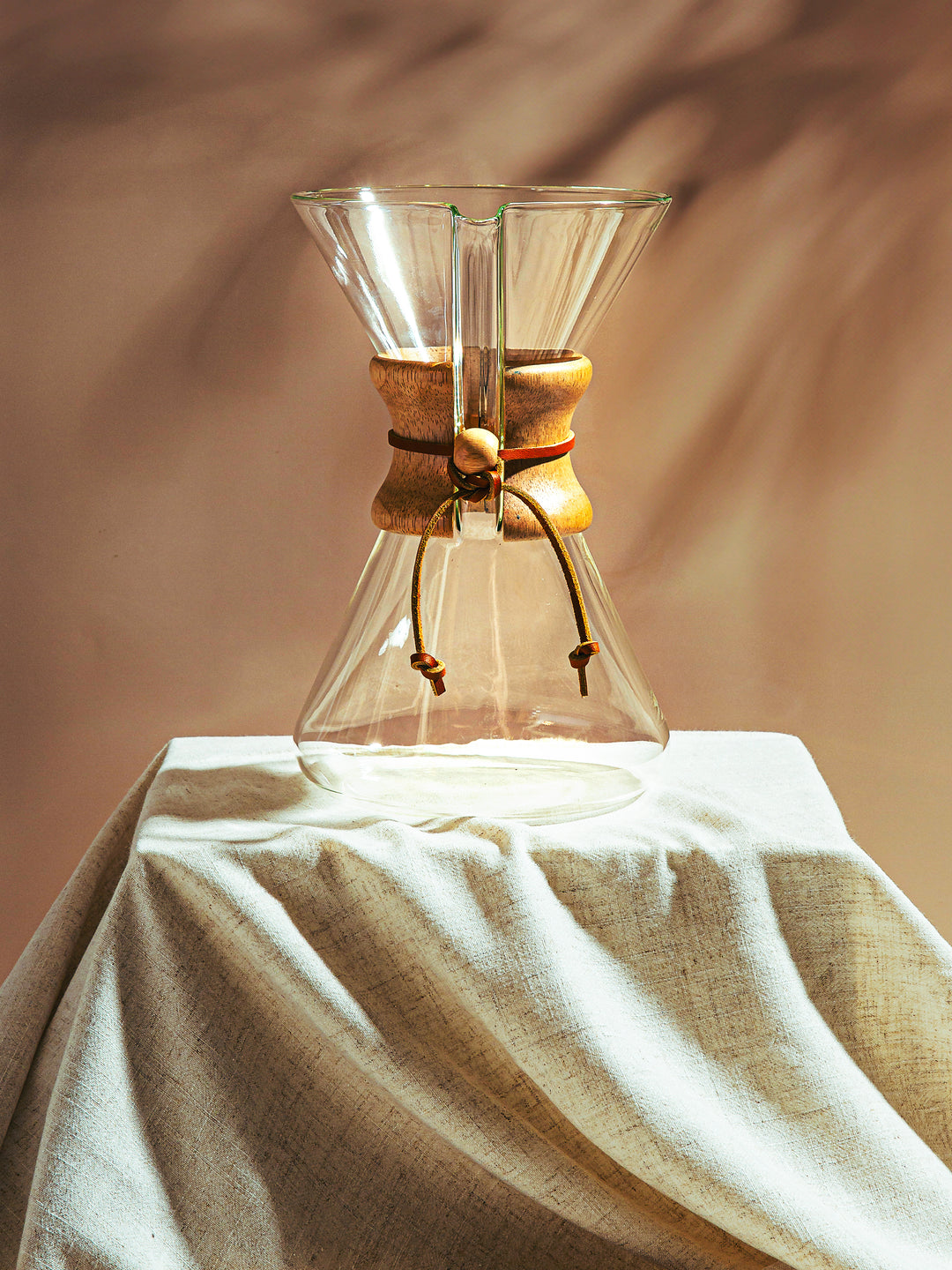 An eight cup handblown Chemex displayed on a podium, making it look like an art piece