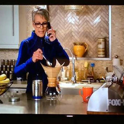 This image shows actress Jamie Lee Curtis starring as Dean Cathy Munsch in the television series Scream Queens brewing a chemex