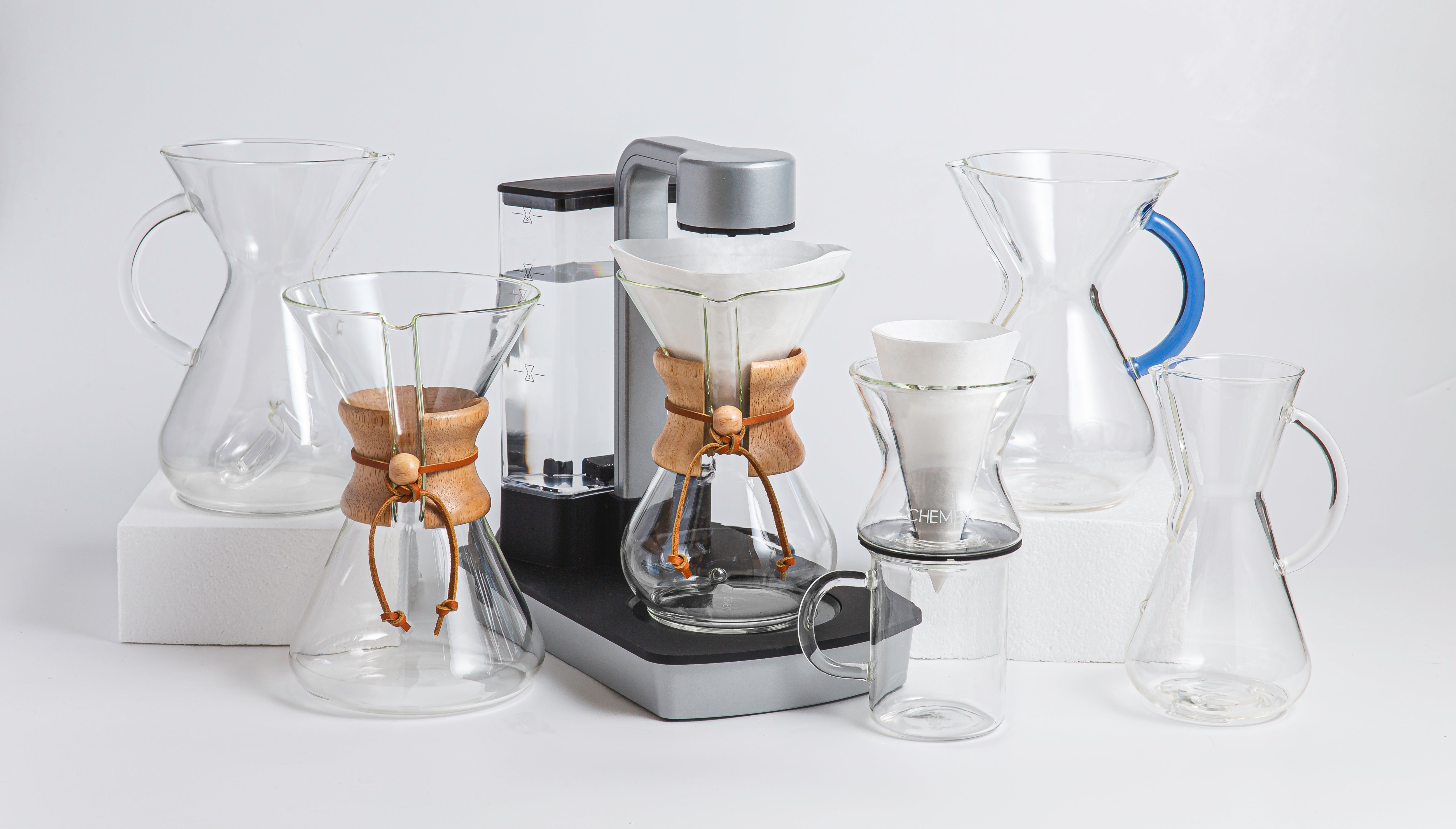 Chemaer, Handblown coffeemaker, Ottomatic, Funnex on a Murray mug, Glass Handle coffeemakers next to each other against a light background