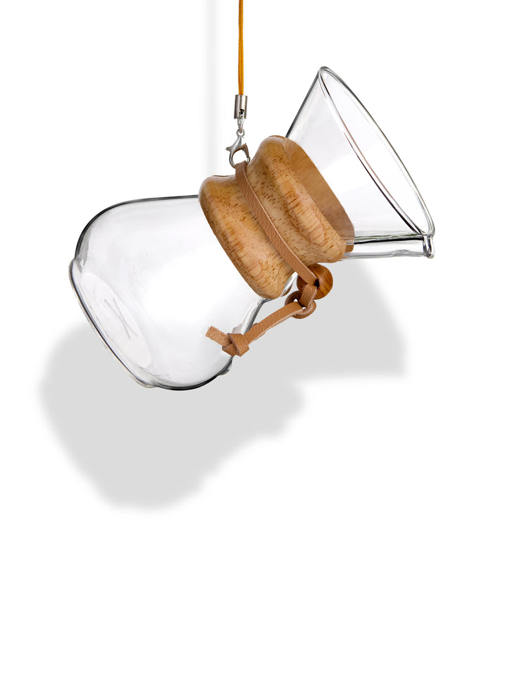 The CHEMEX Ornament, an exactly replica of the CHEMEX six-cup Classic but at 4" tall. The ornament is hanging from a gold colored string against a white background.