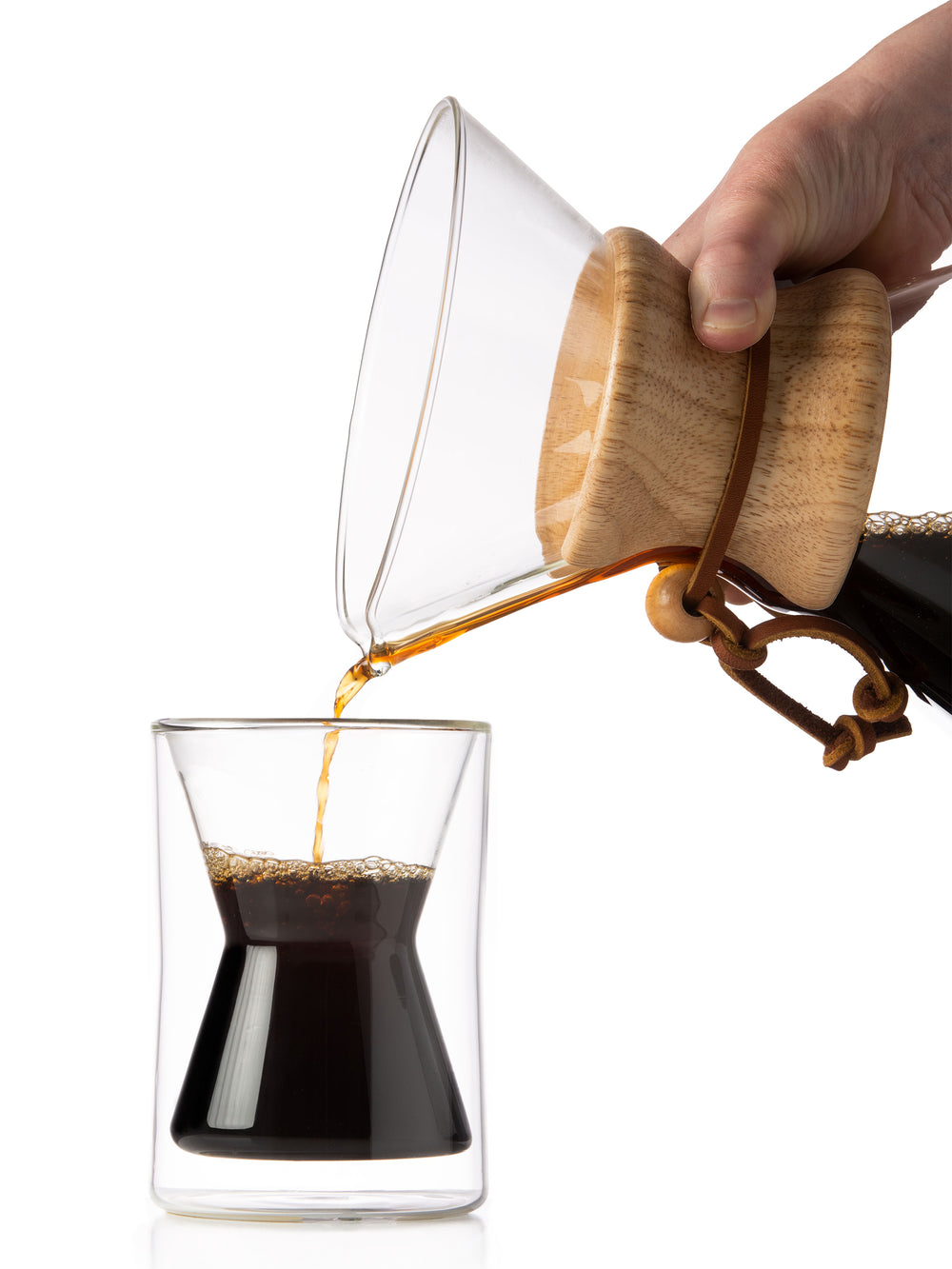classic coffeemaker pouring coffee into a double walled mug on a white background