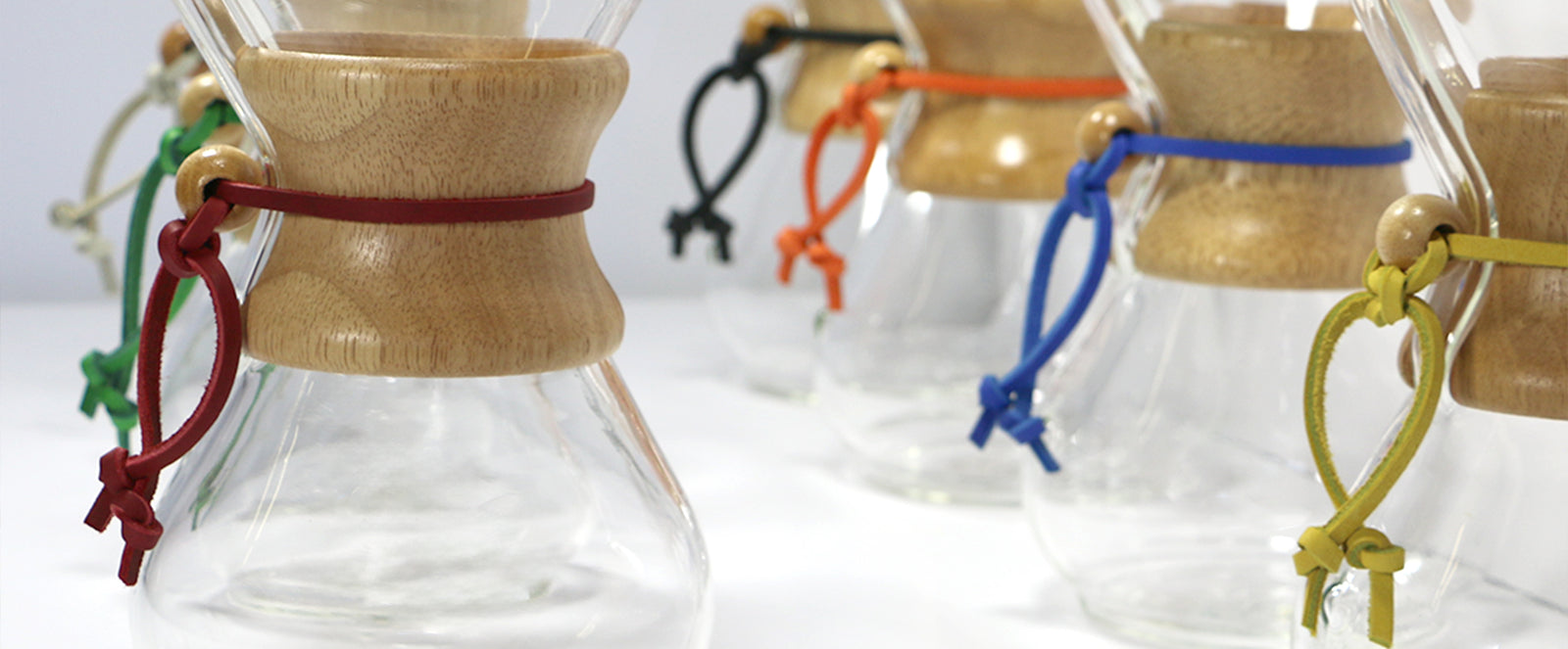close-up of coffeemakers that are all fashioned with a different color rawhide. 